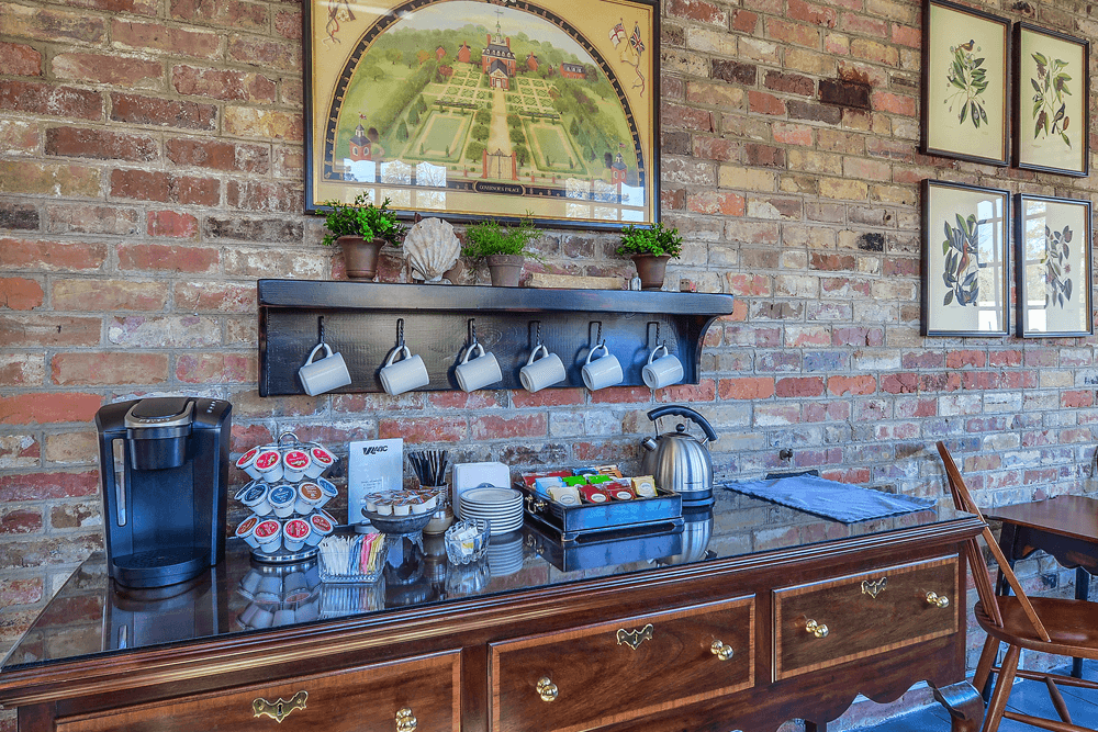 A coffee station in an inn: The image features a wooden table with a coffee maker, cups, sugar, and other coffee-making essentials.
