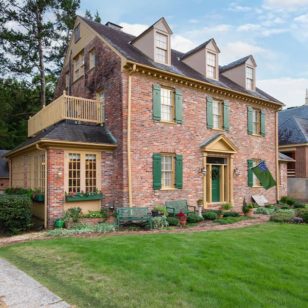 Front of red brick 2 story bed and breakfast with dormers in attic