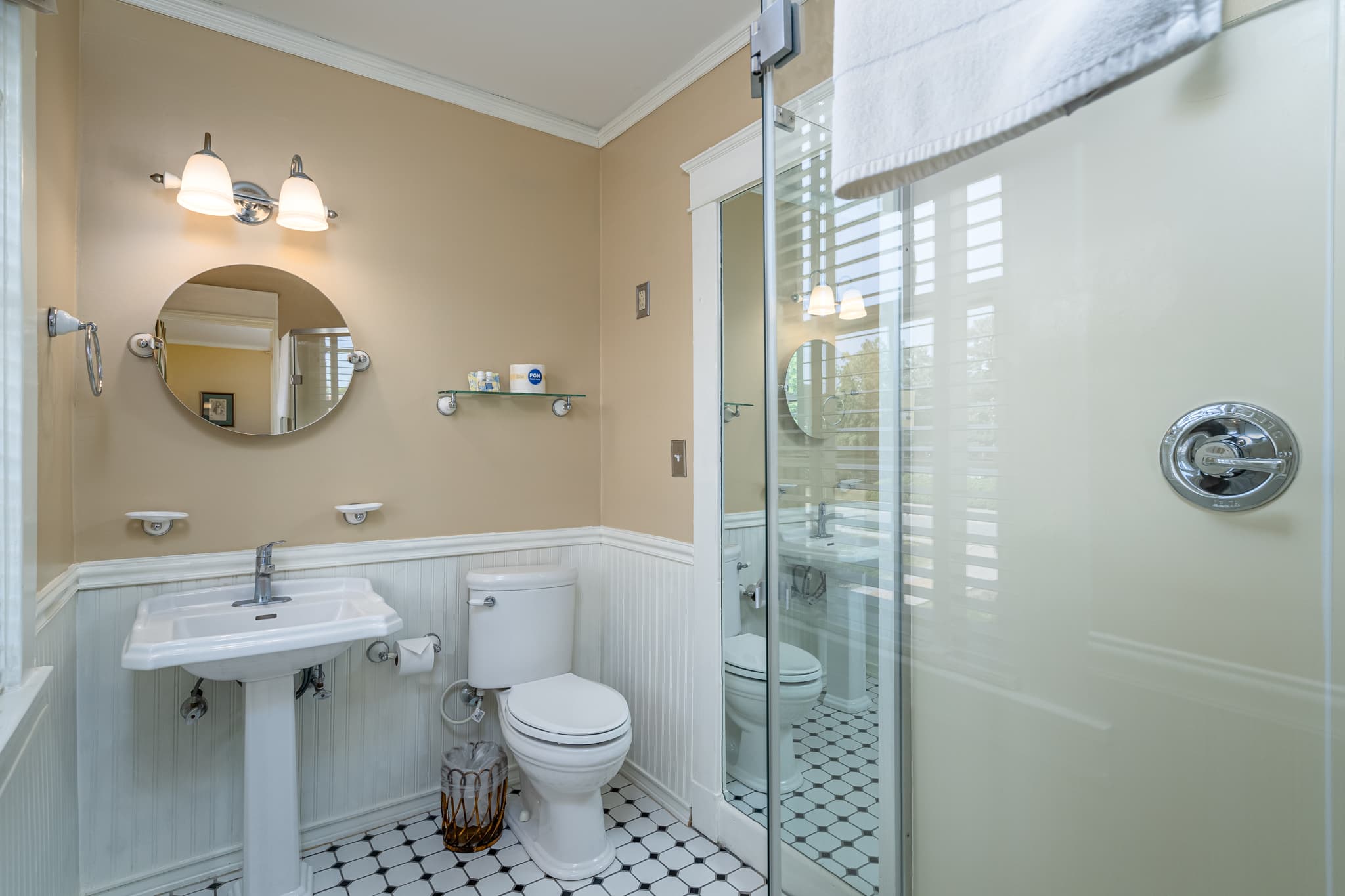 A well-lit bathroom featuring a sink, toilet, and glass shower with modern decor.