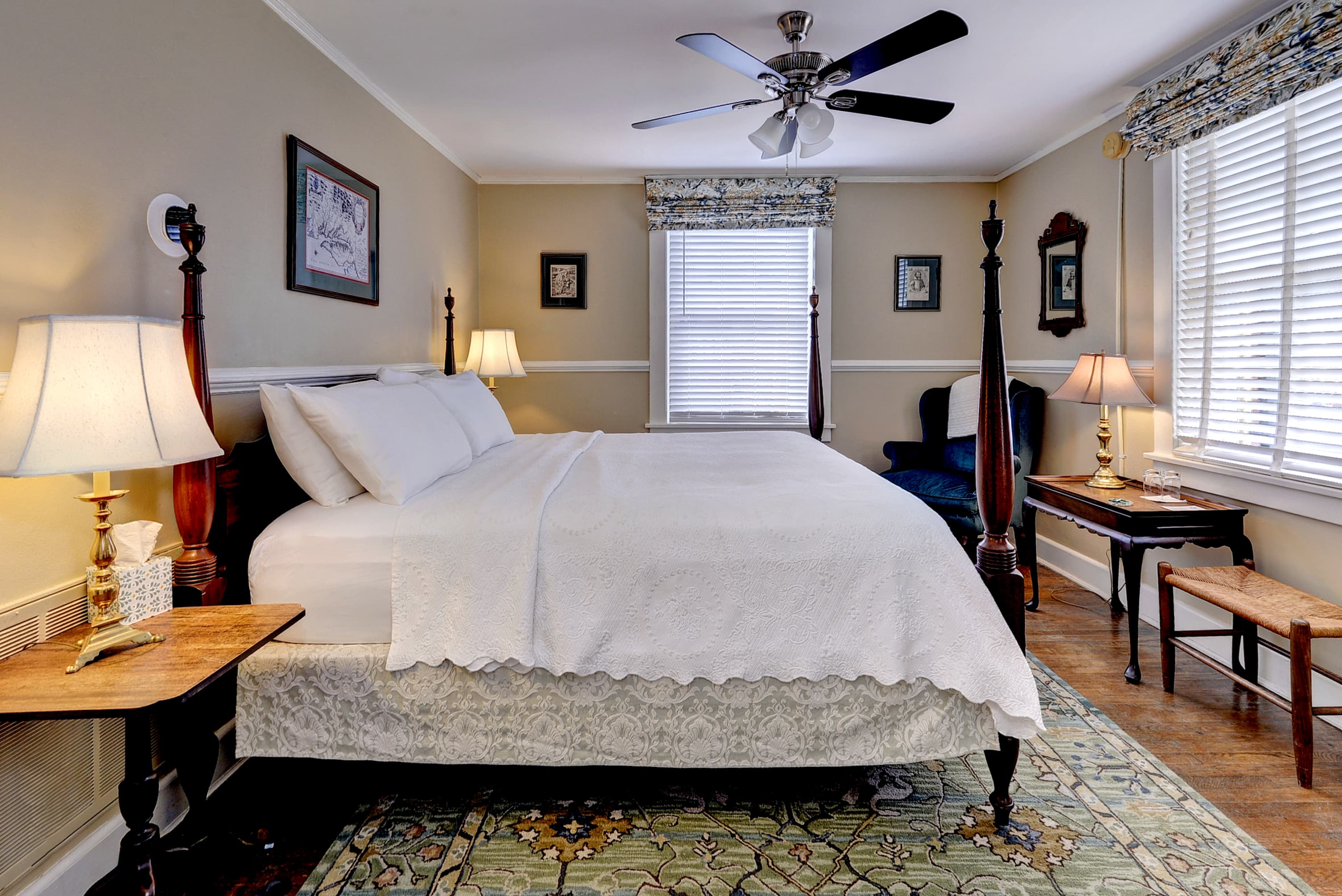 Cozy bedroom with a queen bed, two lamps, and a vintage armchair.